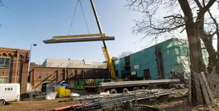 De betonplaten worden op de inbouwbox van de zaal gehesen.