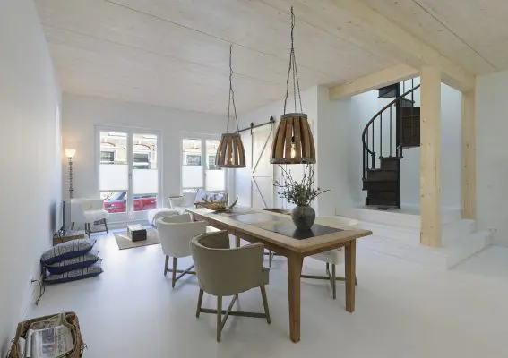 Houten vloeren en houten balken rondom de raveling voor het trapgat geven het interieur een warme uitstraling