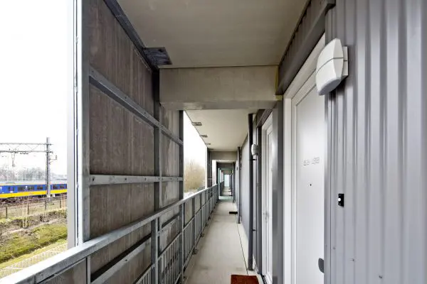 Het hitteschild bestaat uit bekleding van de balustrades en verdiepingshoge panelen ter plaatse van de voordeuren