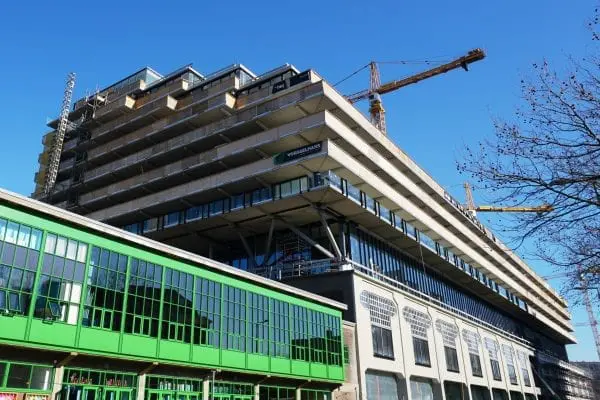De ‘incisielaag’ is extra hoog en heeft een glazen gevel. De appartementen in deze bouwlaag zijn gesitueerd tussen de stalen vakwerken van de tafelconstructie.