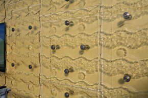 Smeltglazen panelen van gerecycled glas zijn met het SGG-systeem bevestigd op de met wit pvc beklede houtskeletbouw-elementen.