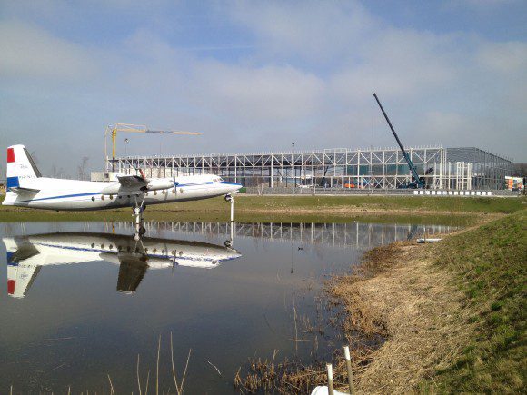 Montage van het staalskelet met op de voorgrond het prototype van de Fokker F27 in een van de nieuwe waterpartijen.