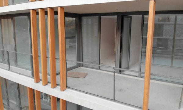 De staanders sieren het balkon en verbinden het gebouw met de groene omgeving